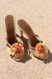 Tutti Frutti raffia mules flat lay on sand — natural raffia stiletto mules with handcrafted starfish and tropical fruit cluster embellishments, Alameda Turquesa insole, handcrafted in Portugal by Alameda Turquesa