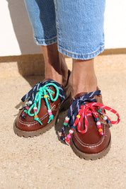 Andie boat shoes pair view — tan leather chunky sole boat shoes with multicolour handcrafted beaded laces in teal, navy and red, worn on body with jeans, handcrafted in Portugal by Alameda Turquesa