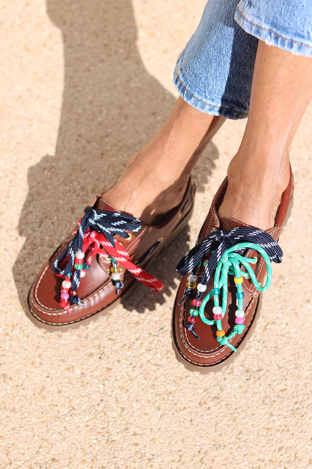 Andie boat shoes top view — tan leather chunky sole boat shoes with multicolour handcrafted beaded laces in navy, red and teal, worn on body with jeans, handcrafted in Portugal by Alameda Turquesa