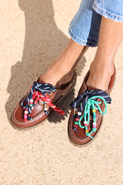 Andie boat shoes top view — tan leather chunky sole boat shoes with multicolour handcrafted beaded laces in navy, red and teal, worn on body with jeans, handcrafted in Portugal by Alameda Turquesa