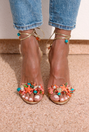 Bahamas heels front view both feet — gold stiletto sandals with wraparound ankle laces and turquoise ankle bead detail, handcrafted coral, starfish, turquoise and pearl sea-motif embellishments at the toe, worn with denim, handcrafted in Portugal by Alameda Turquesa