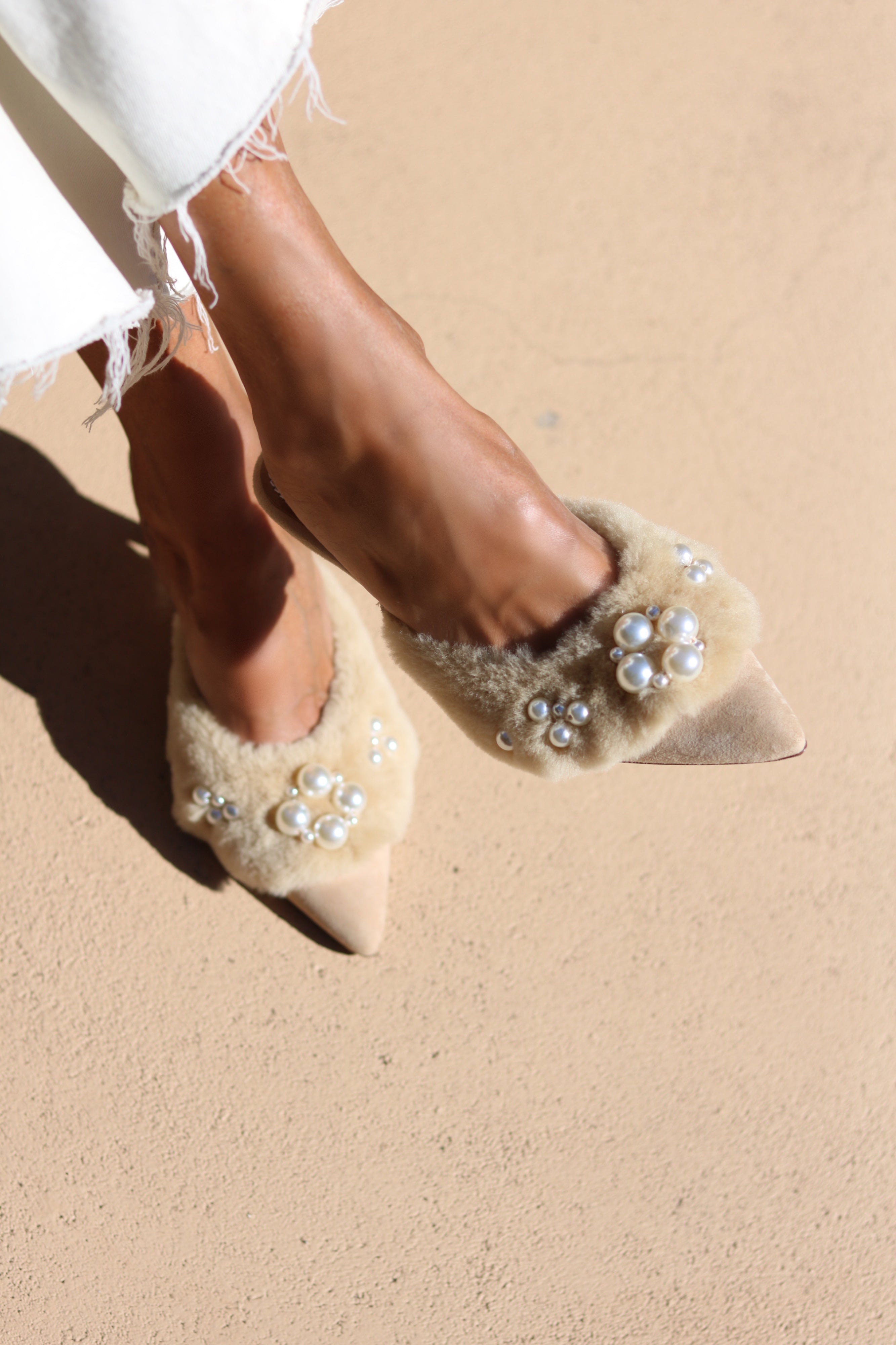 Bella shearling mules top view — cream shearling pointed-toe stiletto mules with hand-applied pearl cluster embellishments, worn on body with white dress, handcrafted in Portugal by Alameda Turquesa