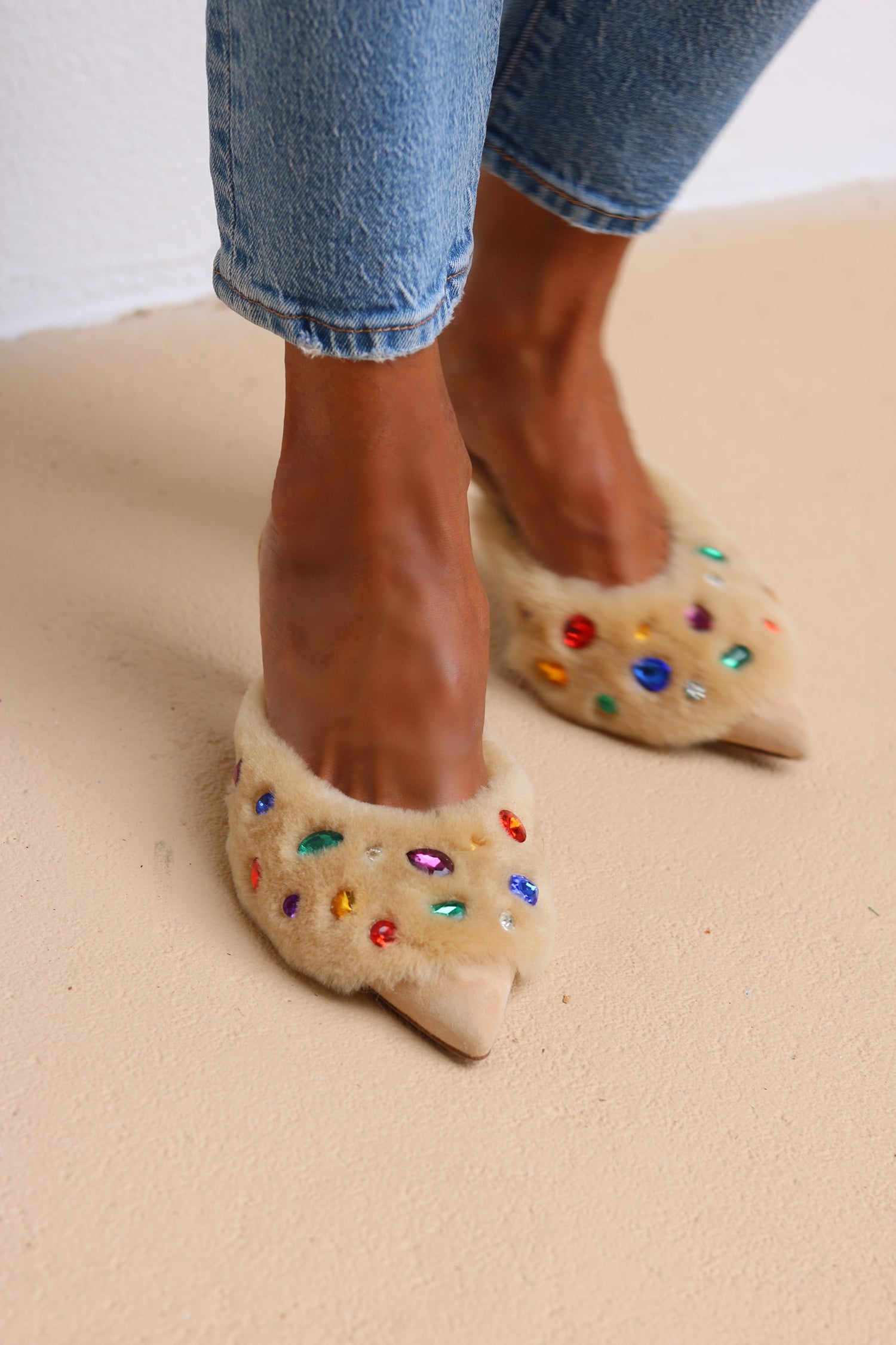 Jasmine Cream shearling gem mules worn with denim
