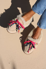 Close-up of Lou shearling moccasins with vibrant pink and navy laces, multicoloured beads, pearl accents and soft genuine shearling.
