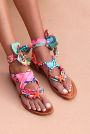 Coralia sandals close-up — hand-printed multicolour fabric flat sandals with orange starfish embellishment and wrap ankle ties, worn on body, handcrafted in Portugal by Alameda Turquesa