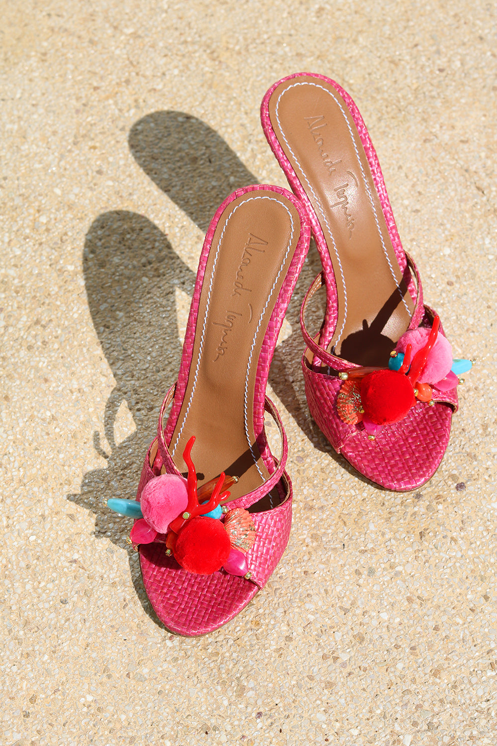 Flamingo mules flat lay — pink woven raffia stiletto heels with handcrafted pom pom and coral embellishments, Alameda Turquesa Portugal