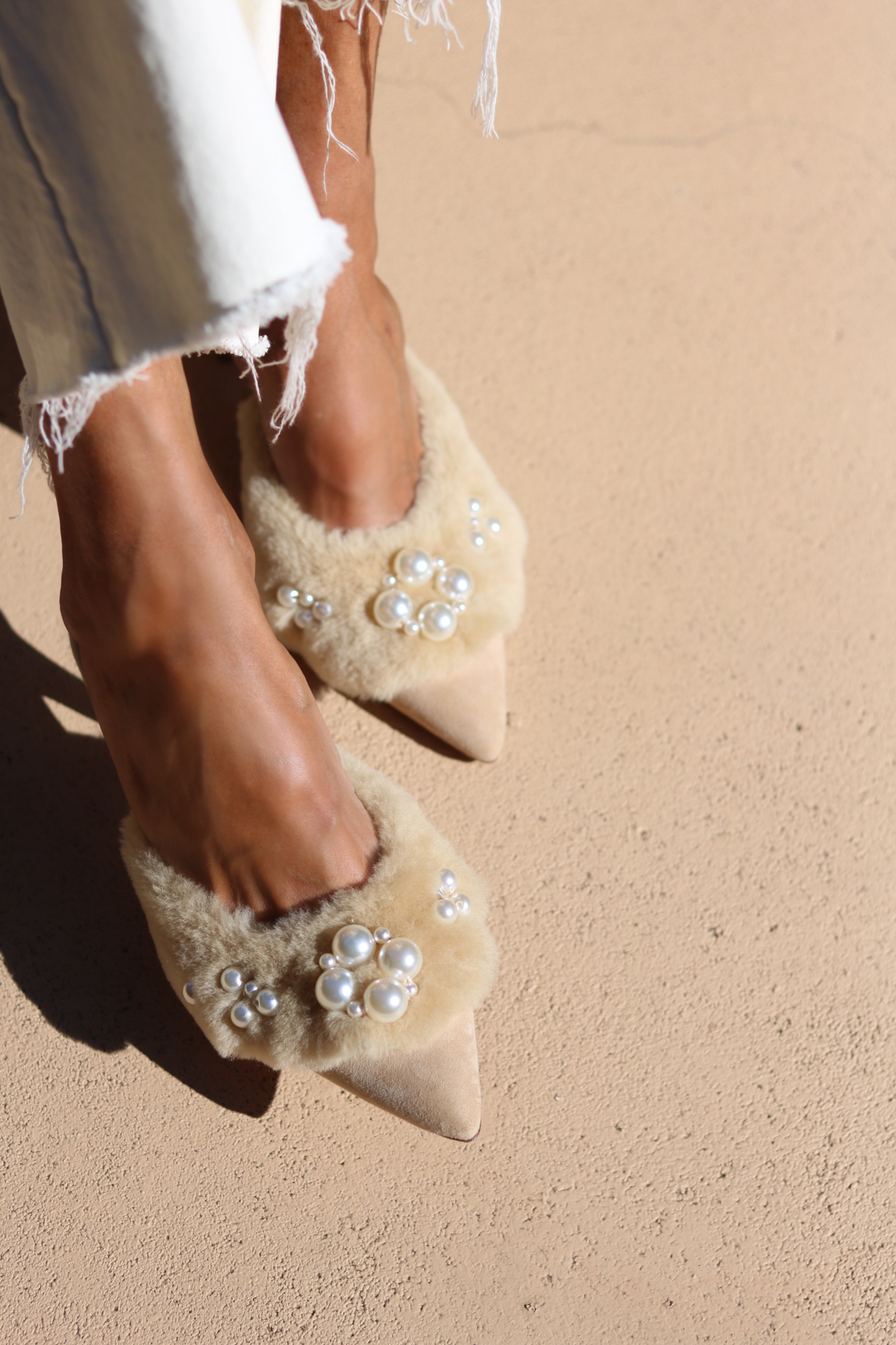 Bella shearling mules close-up — cream shearling pointed-toe stiletto mules with hand-applied pearl cluster embellishments, worn on body, handcrafted in Portugal by Alameda Turquesa