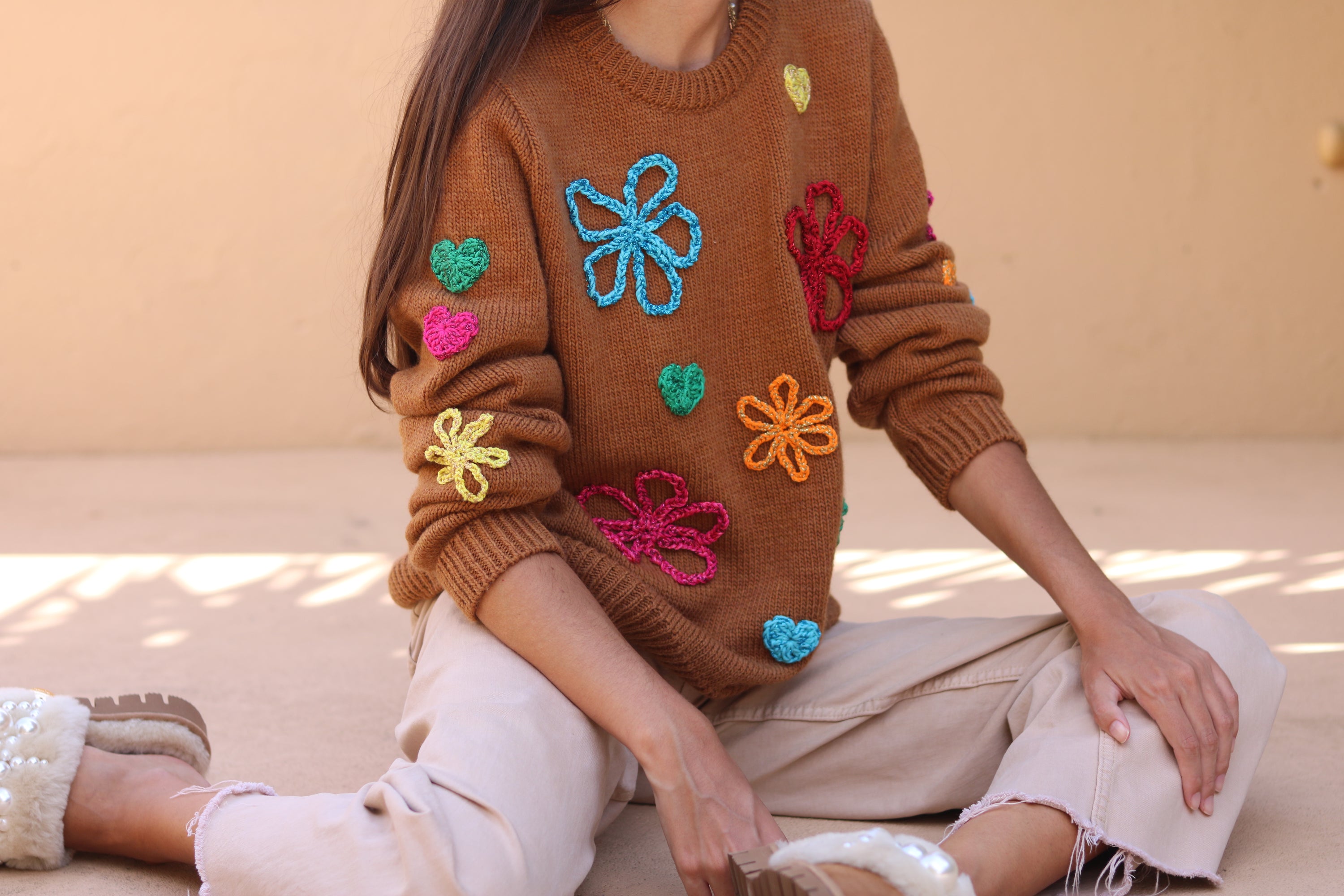 Load video: Video showcasing our newest Ava Knit Sweater. Handmade in Portugal with crochet flowers and hearts