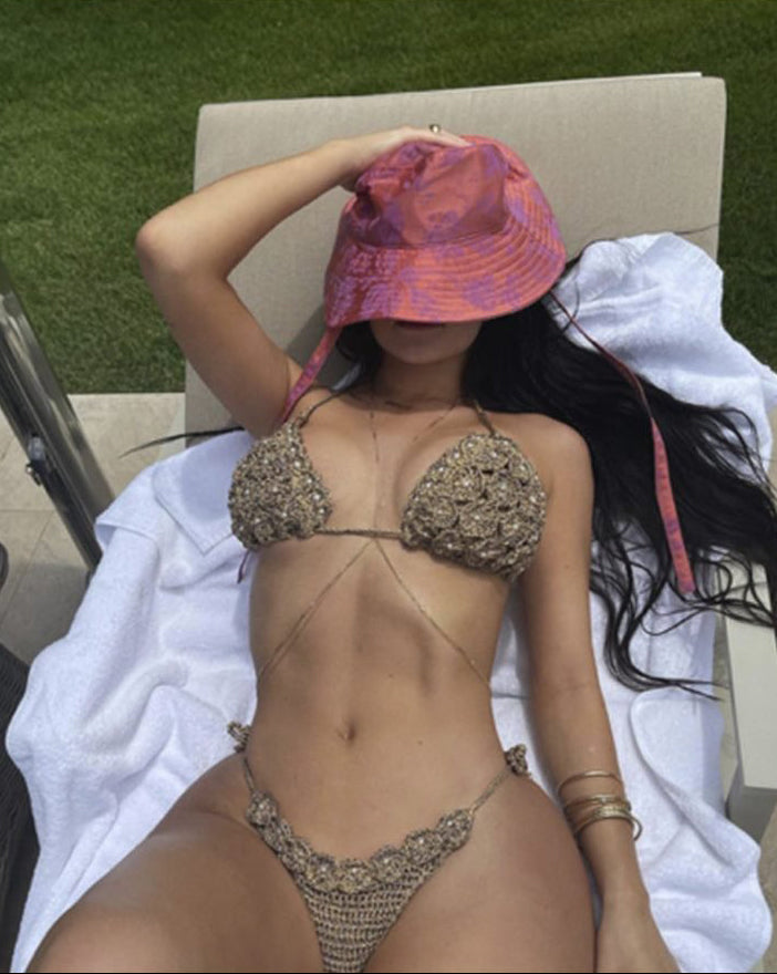 Kylie Jenner wearing Alameda Turquesa handcrafted gold crochet bikini poolside, candid photograph