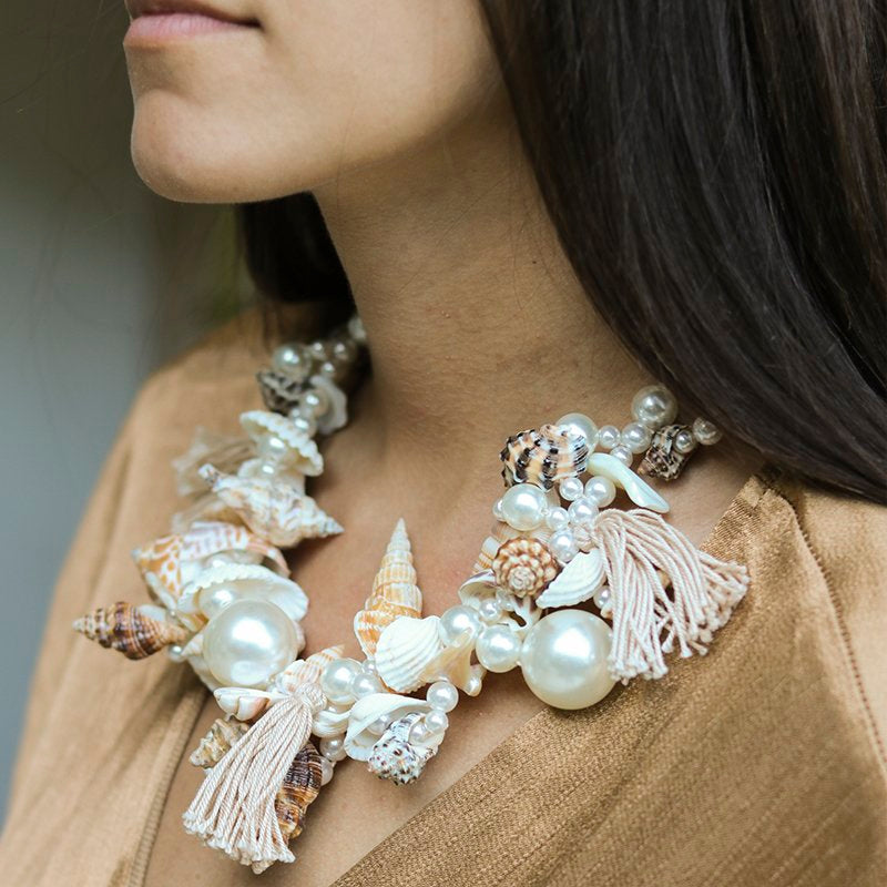 Ariel necklace on body — handcrafted pearl, seashell, coral and tassel statement necklace worn at the neckline, layered shells and oversized pearls with natural tassel details, handcrafted in Portugal by Alameda Turquesa