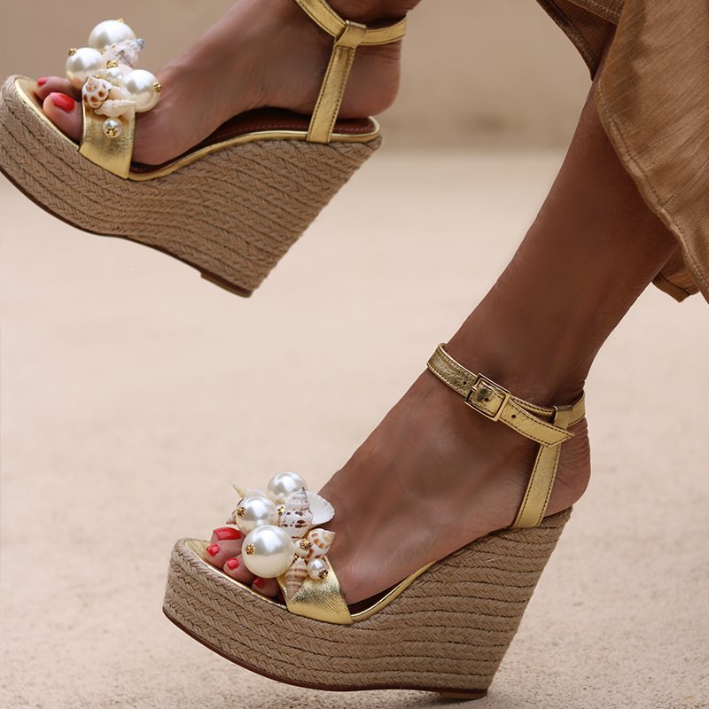Guadeloupe wedges side profile — gold leather wedge sandals with hand-applied oversized pearl and natural shell cluster at the toe, ankle strap with buckle, worn on body, handcrafted in Portugal by Alameda Turquesa