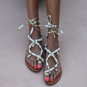 Luz beaded sandals front view — gold leather flat sandals with hand-applied white pearl straps and lace-up ankle ties, worn on body, handcrafted in Portugal by Alameda Turquesa