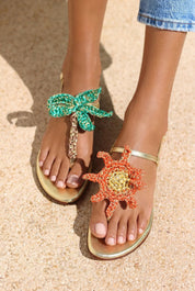 Sunset Dreamer flat sandals — gold leather thong sandals with handcrafted crochet palm tree and sun motifs in emerald green and orange, handcrafted in Portugal by Alameda Turquesa